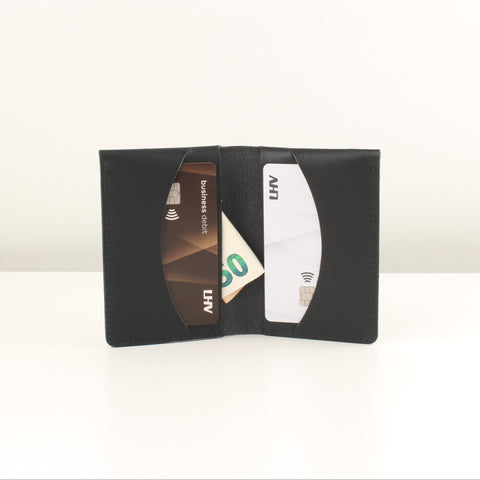 Black cardholder with cards and money on a white background