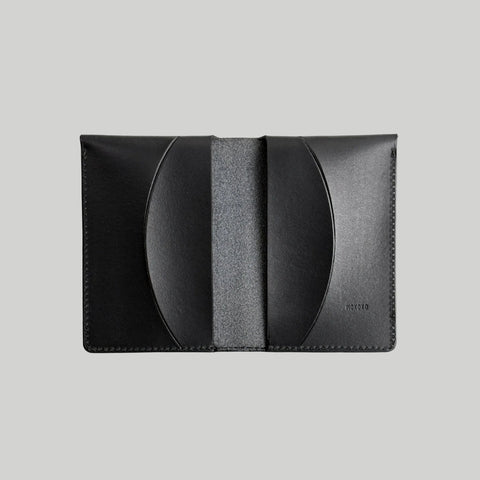 Black leather cardholder on a light gray background