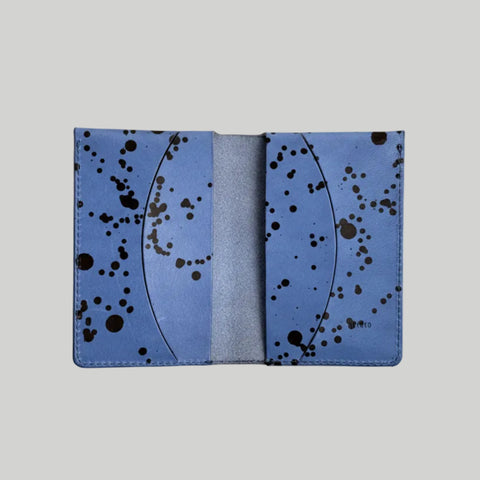 Blue cardholder with black abstract pattern on a light gray background
